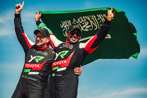 Timo Gottschalk and Yazeed Al-Rajhi holding up the Saudi Arabian flag and celebrating their victory